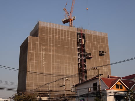An Urban Construction Site Featuring a Crane and a Structure That is Currently Rising Upwards photo