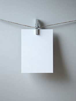 Blank white paper hanging on twine with clothespin on grey background photo