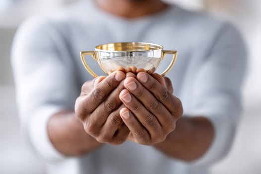 Hands celebrate achievement while holding a vibrant trophy of success and accomplishment photo