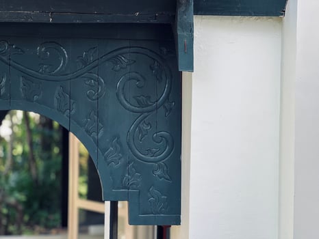Wooden decorative archway featuring intricate floral motifs with swirling patterns and a central medallion. photo