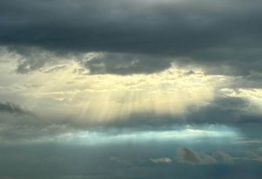 Rays of sun break through dark clouds in anticipation of thunderstorm. photo