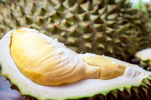 A durian fruit is cut open and sitting on a table photo