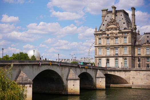 Parisian bridge and historic architecture with summer sky and ferris wheel photo
