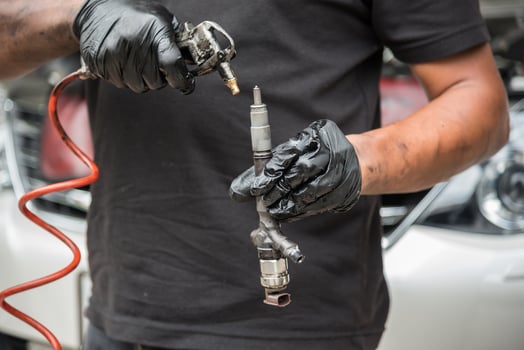 A man in black gloves holding a hose and a car photo
