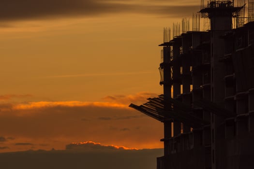 A plane flying over a building under construction photo