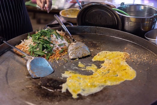 A person is cooking food on a pan photo