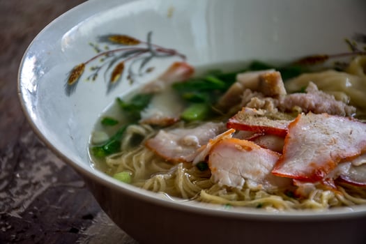 A bowl of soup with meat and vegetables in it photo