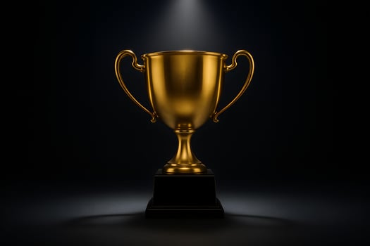 Golden Trophy on Black Base Bathed in Spotlight Symbolizing Achievement and Success photo