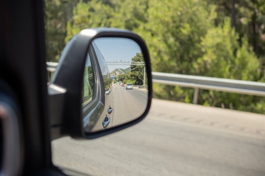 Reflection of a Road Trip on a Sunny Day Along a Scenic Highway With Green Trees photo