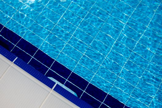 Clear Blue Water in a Swimming Pool With Tiled Edges on a Sunny Day in a Residential Area photo