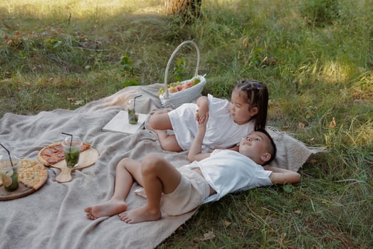 Siblings Relaxing at Summer Picnic Outdoors Family Bonding and Childhood Joy in Nature photo