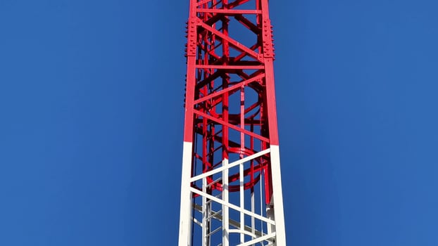 A HighDefinition Transmission Tower Soaring Against a Brilliant Blue Sky Above the Landscape photo