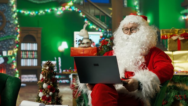 Happy Santa Claus nodding head, reading pleasing internet posts bringing positivity and joy, agreeing with online posts on social media spreading sense of wonder during Christmas, camera A photo