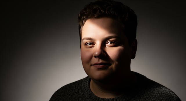 Person with Smiling Face and Dark Hair in Dramatic Studio Lighting photo