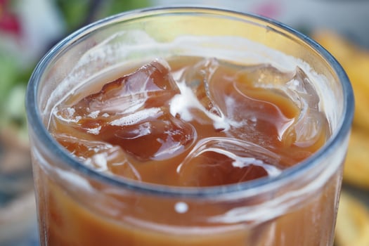 Iced coffee with ice cubes served on a sunny day photo