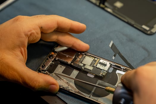 Expert Hands Perform Phone Repair on a Disassembled Device in a Workshop Setting During Daylight Hours photo