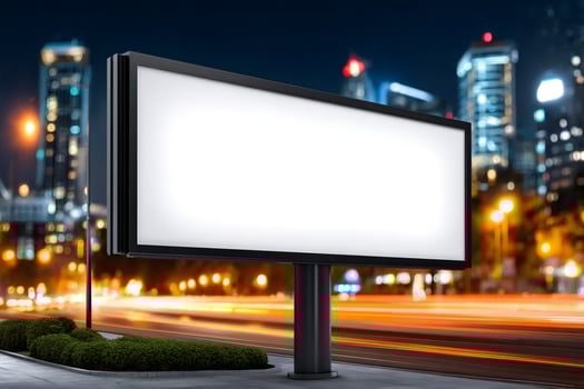 Blank billboard by busy road at night showing motion blur of traffic photo