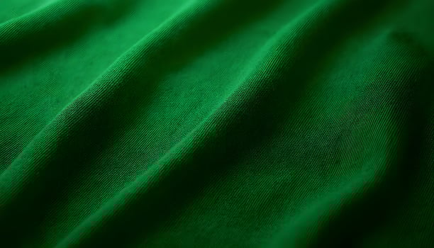 Green Fabric Close-up Showing Texture and Folds in a Dark Lighting photo