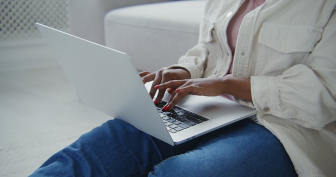 A woman sitting on a couch with her laptop photo
