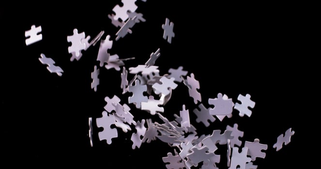A pile of white puzzle pieces falling to the ground photo