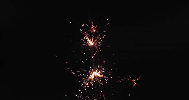 A sparkler is lit up in the dark photo