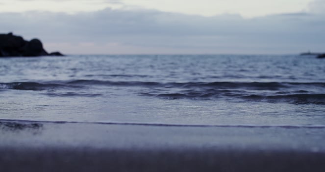 A person standing on a beach with a surfboard photo