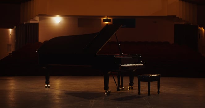 A black grand piano in an empty auditorium photo