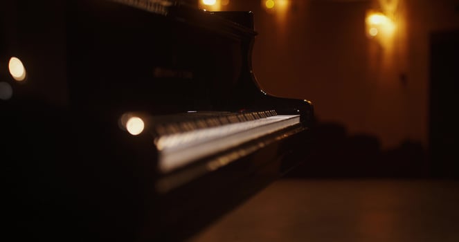 A piano is shown in a dimly lit room photo