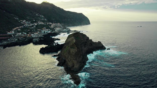 A rocky island in the ocean with a small town on top photo