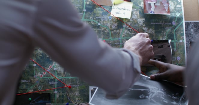 A man is pointing to a map on a table photo