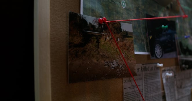 A red string attached to a bulletin board photo