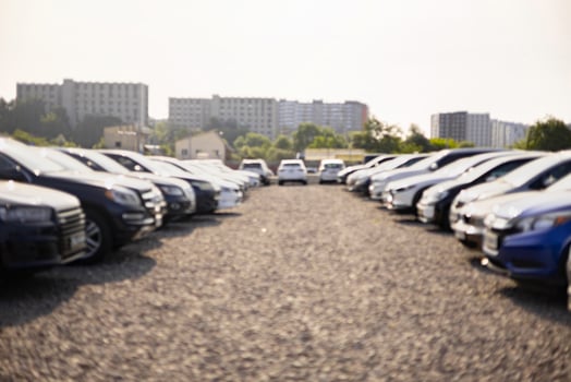 A row of cars for sale is shown outdoors on a sunny day, showcasing various makes and models. photo