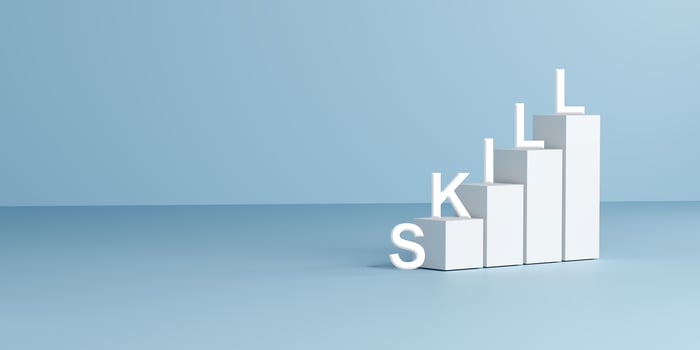 Skills spelled on white blocks arranged as ascending steps, set against a light blue background, symbolizing growth, learning, career development, up skills, and personal improvement. 3D render photo