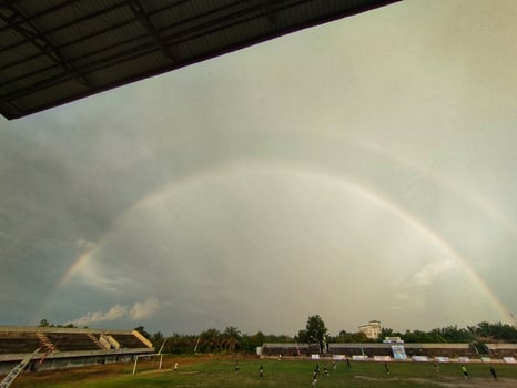 A double rainbow is seen over a soccer field photo