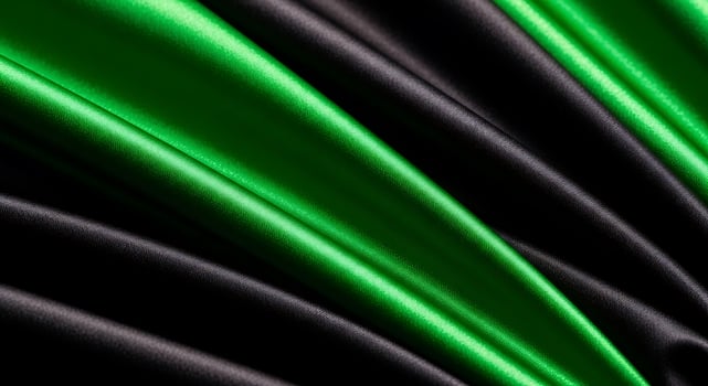 Close up of flowing green and black satin fabric creating a luxurious and elegant background texture photo