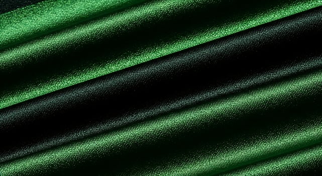 Close up of folded dark green and black fabric with a shiny textured surface in a diagonal pattern photo
