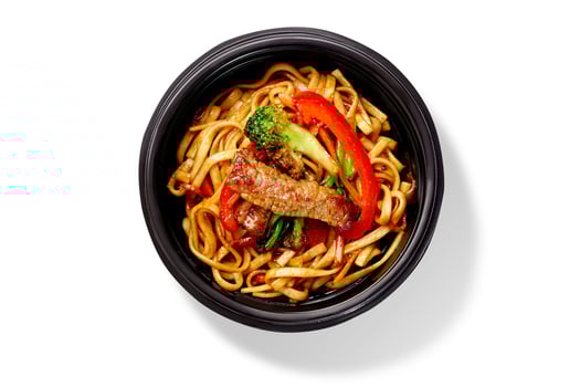 Udon noodles with beef and vegetables in takeaway bowl on white background photo