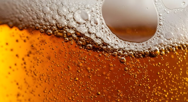 Dark beer in a glass close-up, bubbles and beer foam. photo