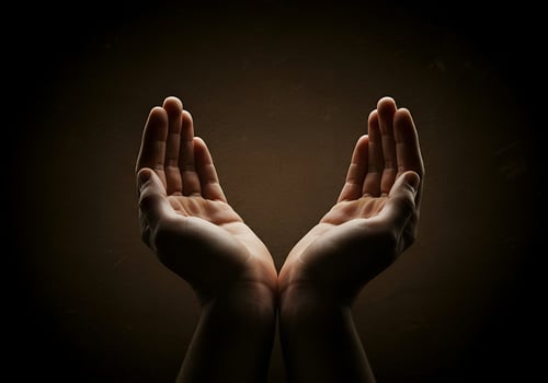Hands reaching out to the sky, with a dark background photo