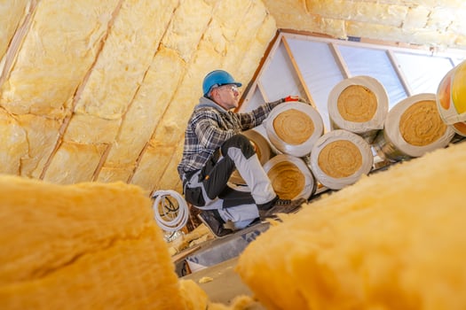 Worker Installing Mineral Wool Insulation in a Residential Attic During Daytime Renovation Process photo