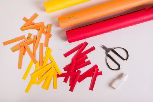 Strips of colored paper, scissors and glue to make paper garlands top view photo