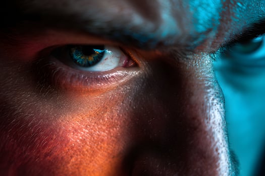 Close Up of Human Eye with Bright Blue and Gold Iris in Dramatic Lighting photo