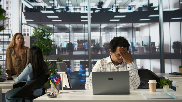 Overworked frustrated employee faces a migraine from pressure, dealing with burnout after a failure. Man feeling overwhelmed by deadlines and professional struggles, emotional strain. Camera B. photo