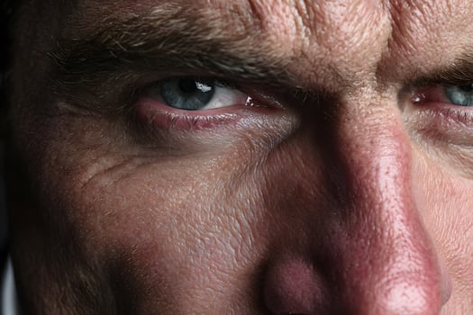 Close-up of Man Face with Intense Blue Eyes and Wrinkled Skin Showing Determination photo