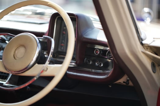 The dashboard of a vintage classic car features detailed analog gauges, a radio, and air vents in polished wood and chrome, offering a fresh yet luxurious look.hb photo