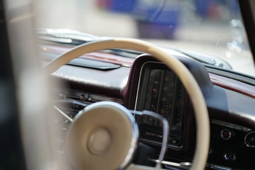 The dashboard of a vintage classic car features detailed analog gauges, a radio, and air vents in polished wood and chrome, offering a fresh yet luxurious look.fb photo