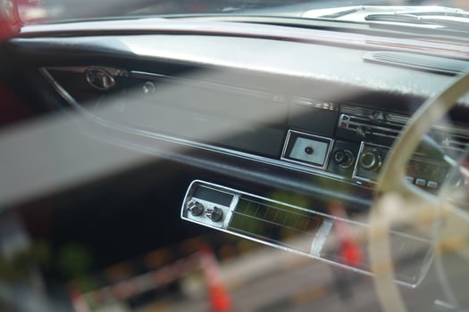 The dashboard of a vintage classic car features detailed analog gauges, a radio, and air vents in polished wood and chrome, offering a fresh yet luxurious look.ec photo