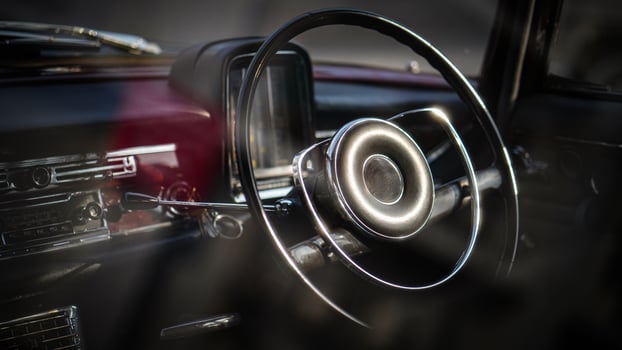 Vintage Classic car steering wheel, with chrome and leather textures in sharp detail, showcases the quality and precision of automotive craftsmanship under natural light.bt photo