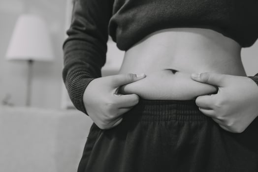 A woman is holding her stomach in black and white photo