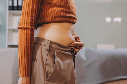 A woman with her stomach exposed in a room photo